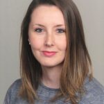 Headshot of female with brunette hair. Works on effective parenting techniques.